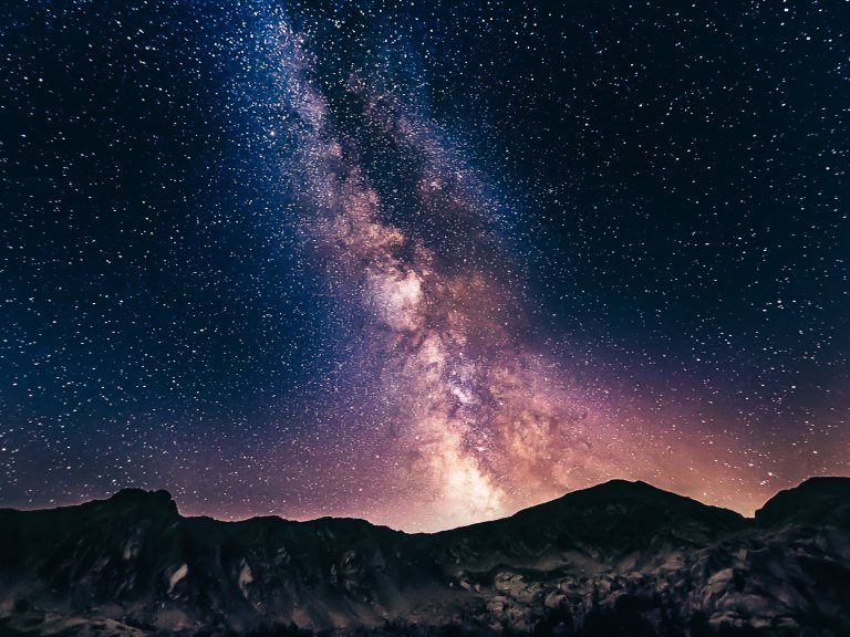 The Milky Way at night over mountains.