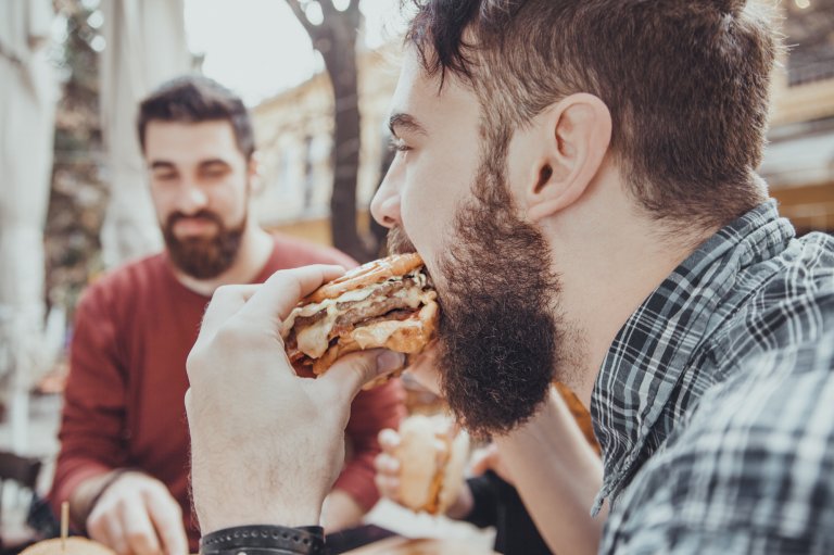 man eating fast food hamburger