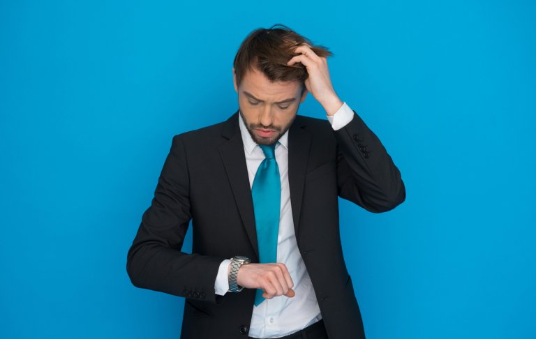 person in rush looking at his watch , running late sorting out his hair