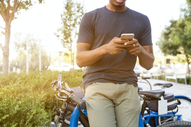 person leaning against his bike with his phone