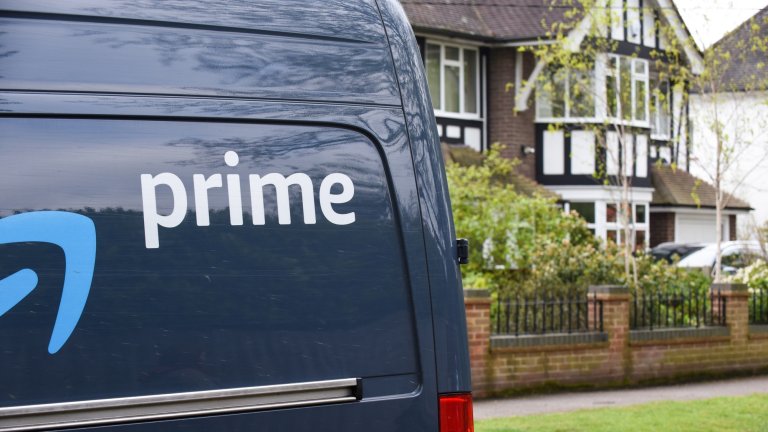 Van with Amazon Prime logo makes a delivery to a residential street